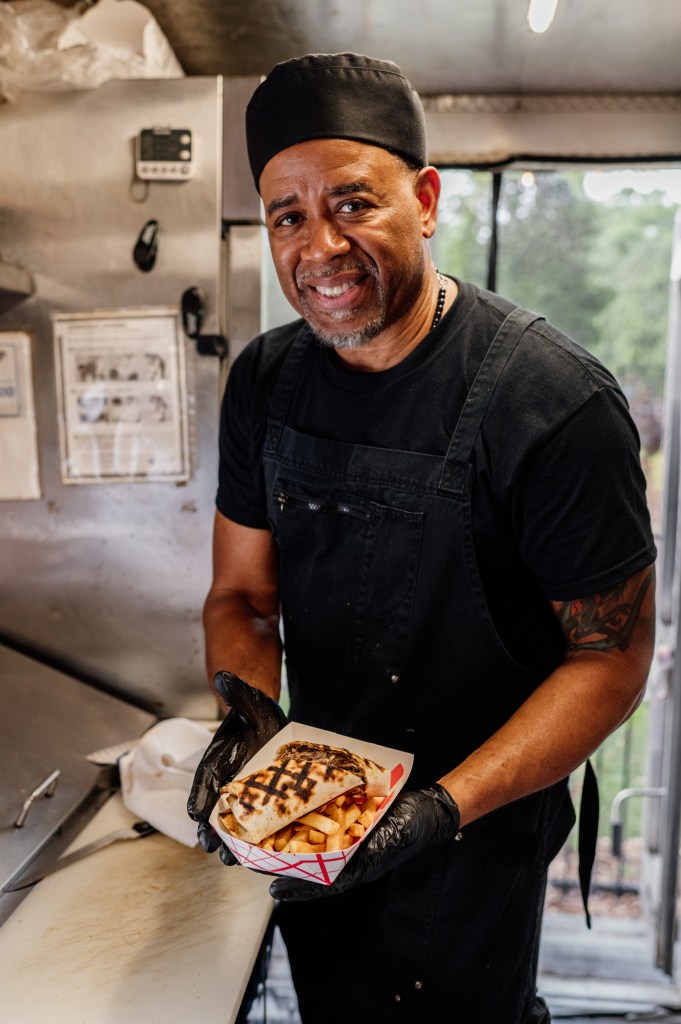 Chef Ernie Hines presents a wrap he made inside his Spice the Americas food truck.