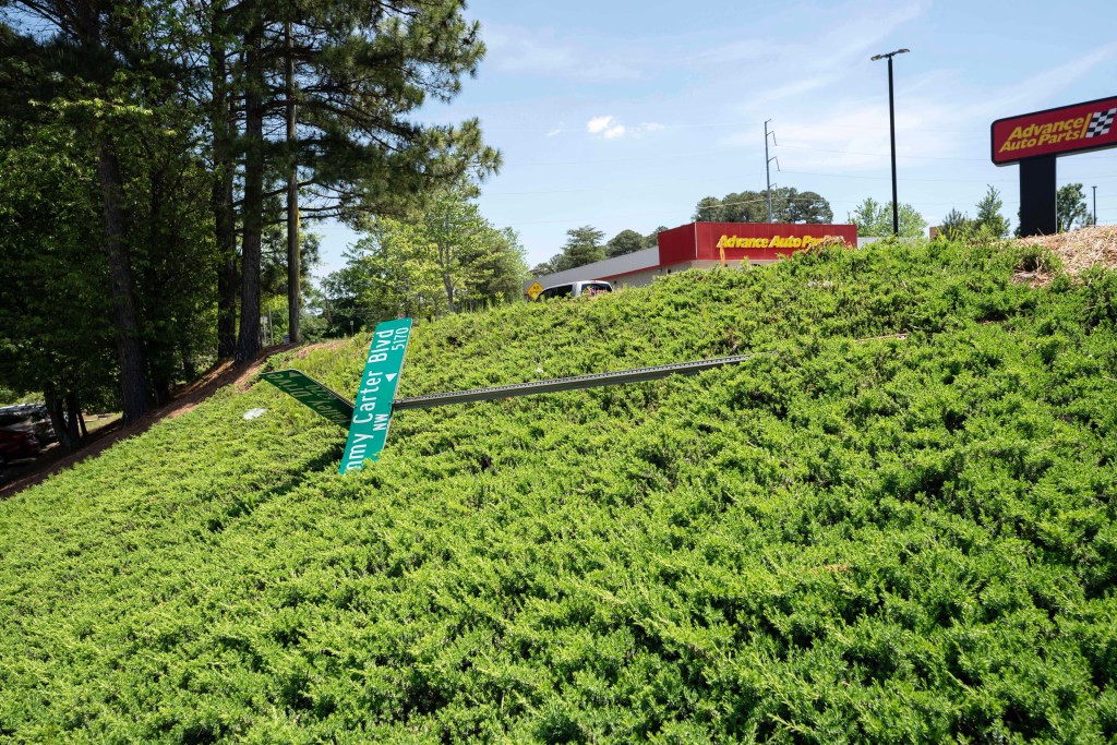 A old, fallen street sign for Jimmy Carter Boulevard lays beside Gale Drive in Norcross.