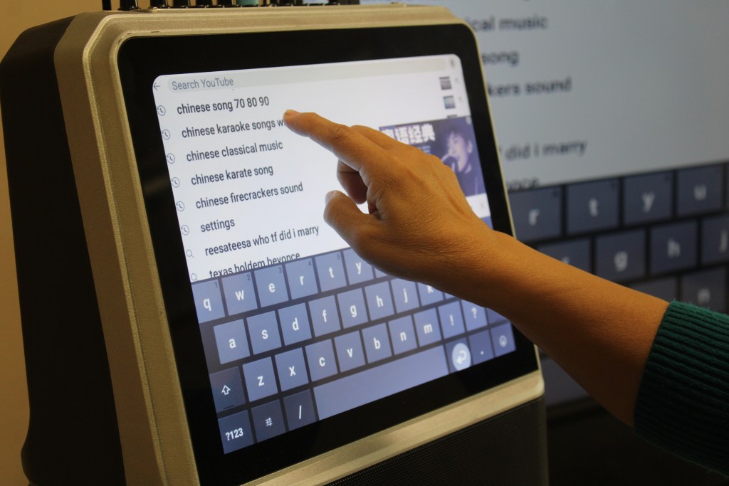 Seniors use a touchscreen to select which songs to sing at karaoke at the Chinese Community Federation of Atlanta in Norcross.
