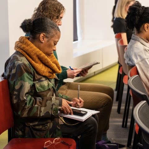 Documenters Danielle Bryant (with scarf on left) and D'Asha Davis (right) take notes during an Invest Atlanta Board of Directors meeting on Thursday, Feb. 16, 2023. Photo by Dean Hesse.
