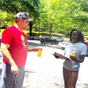 Pristine Parr interviews a man in a parking lot for the Voting Bridges and Barriers Project.