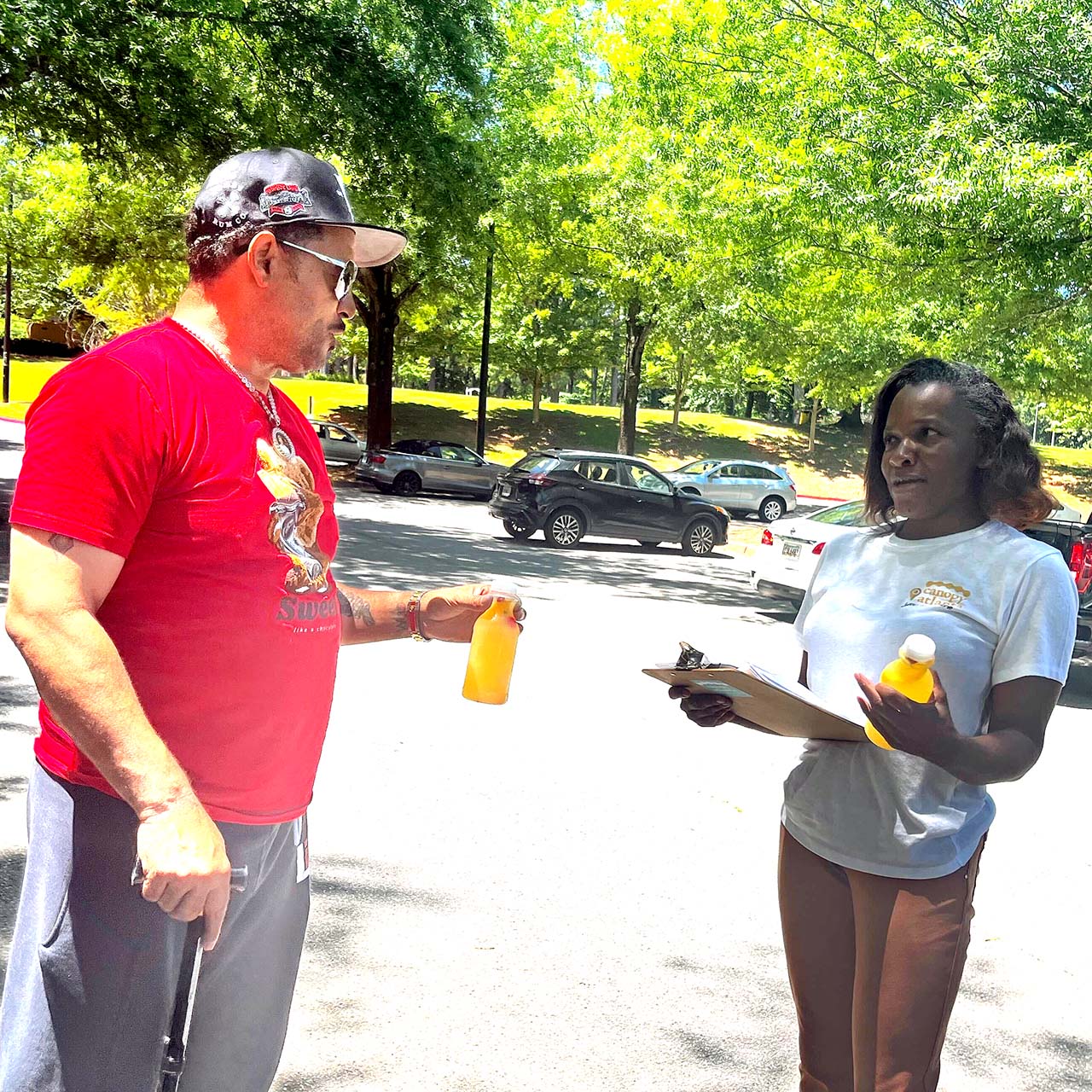 Pristine Parr interviews a man in a parking lot for the Voting Bridges and Barriers Project.