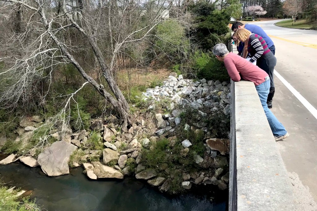 People stand over a bridge overlooking the Flint River headwaters in Clayton County, Georgia.
