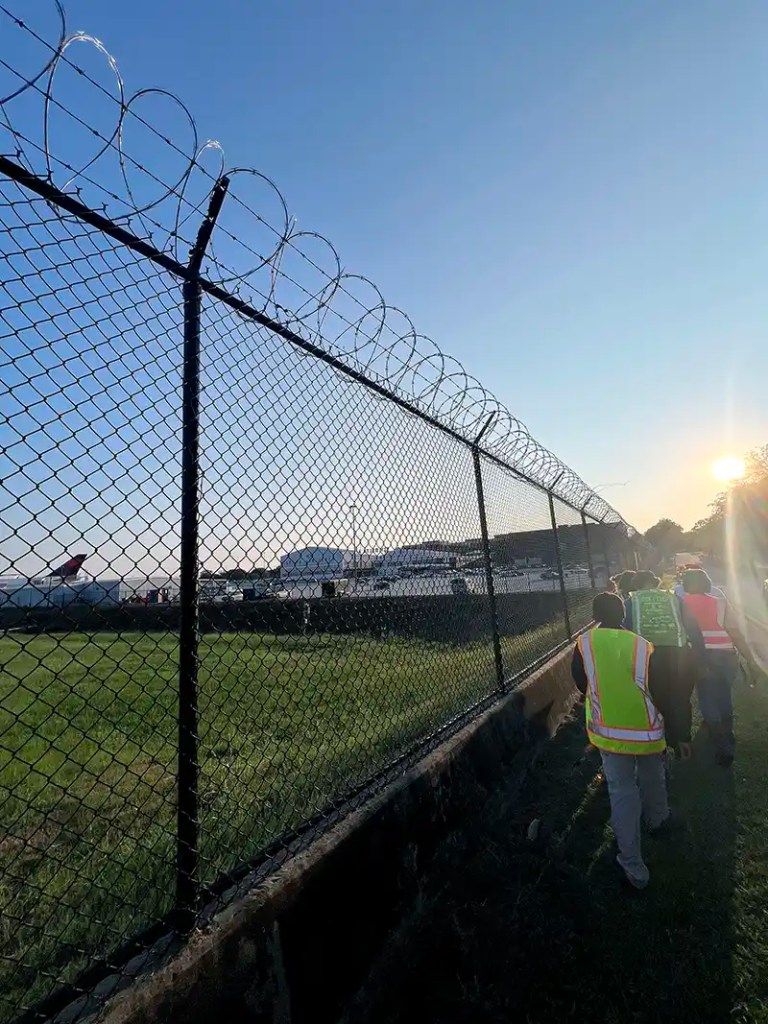 Metro Atlanta residents touring the Flint River walk beside a chain link fence next to the Delta Flight Museum in Hapeville, Georgia.