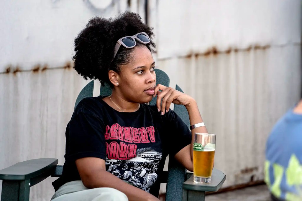 A woman sits with her beer on a patio chair outside Atlanta Utility Works in East Point, Georgia.