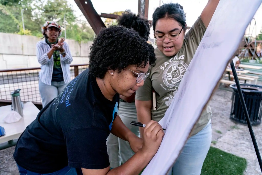 A woman jot down ideas on an easel pad during a meeting.