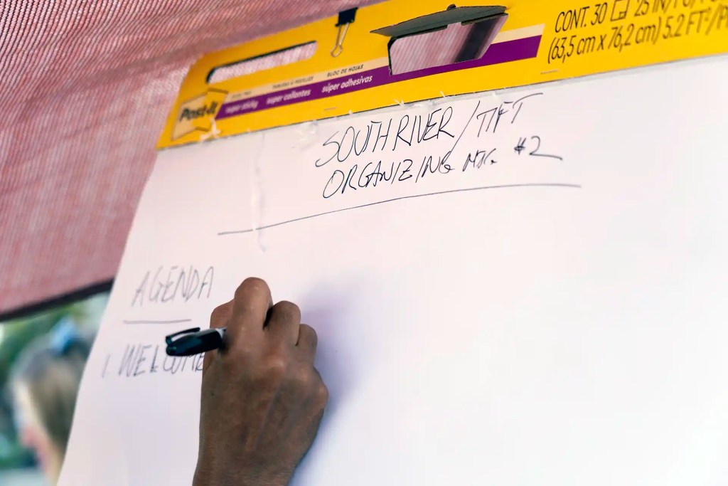 A Tri-Cities resident writes an agenda for a meeting discussing the South River in metro Atlanta.