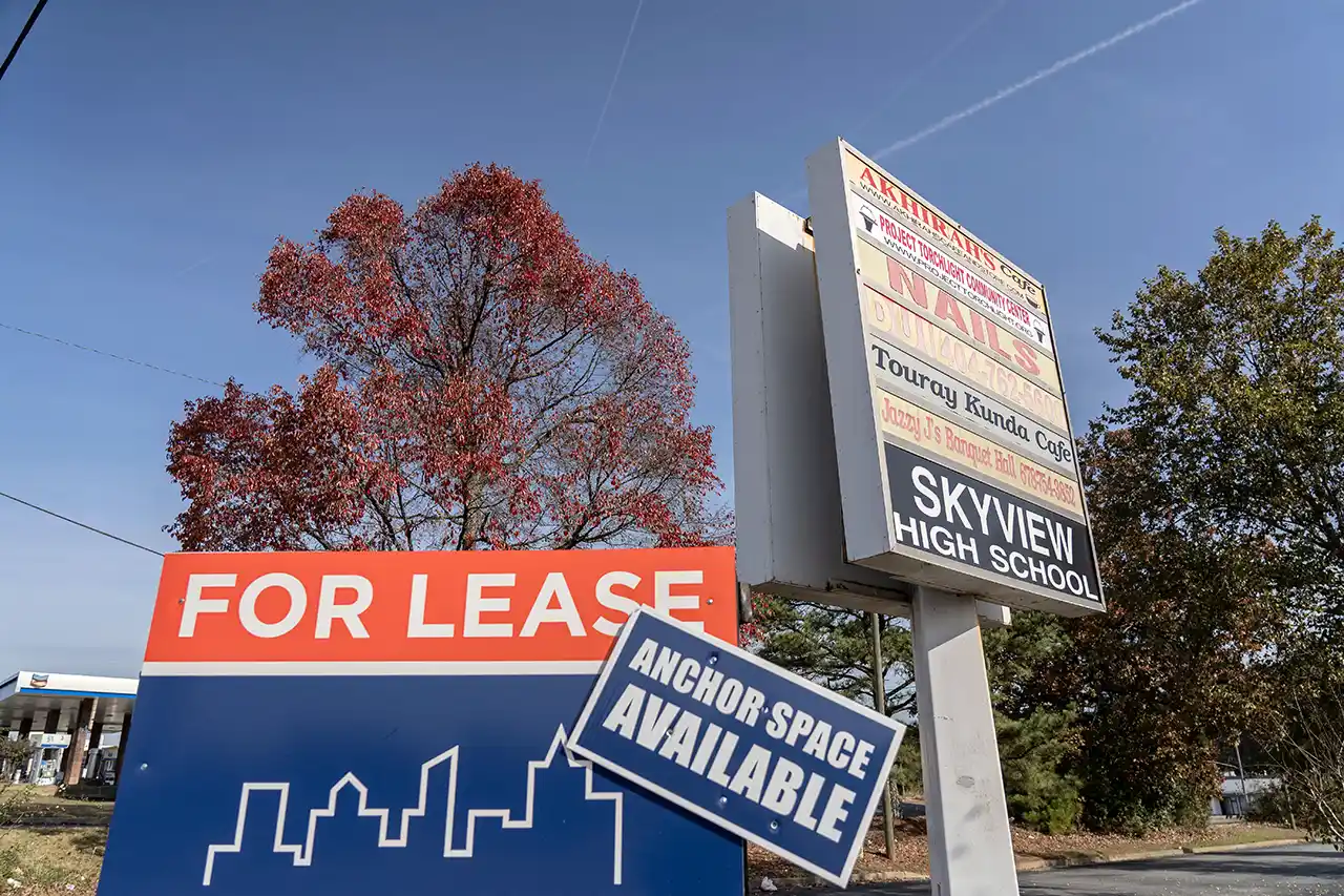 A sign advertising retail space for lease at a shopping district on Old National Highway.