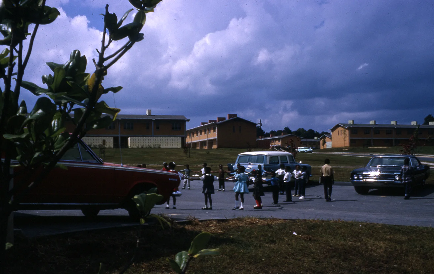 Schoolchildren form a circle to play outside in Bowen Homes.